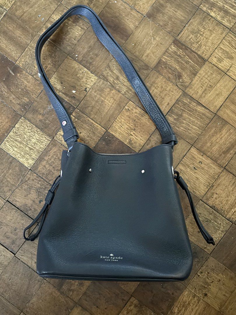 Kate Spade Black Leather Bucket Bag (Category: Luxury Bags & Wallets) located in Marikina City. Submitted by qtiefinds (Listing ID 1463181508, Image 2). Description: - Authentic Kate Spade black leather bucket bag - Unique heart-shaped clasp closure on the front - Interior zip pocket and slip pocket for organization - Adjustable shoulder strap for comfortable wear - Minor scuffs on exterior leather, interior is clean.