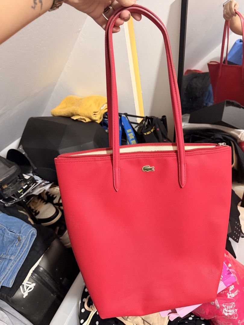 Lacoste Red Tote Bag (Category: Tote Bags) located in Santa Rosa. Submitted by hello2ndhandlove (Listing ID 1463142139, Image 1). Description: - Classic red Lacoste tote bag - Features the iconic crocodile logo - Spacious interior for all your essentials - Secure zip closure - Comfortable shoulder straps - Ideal for everyday use or travel Authentic.
