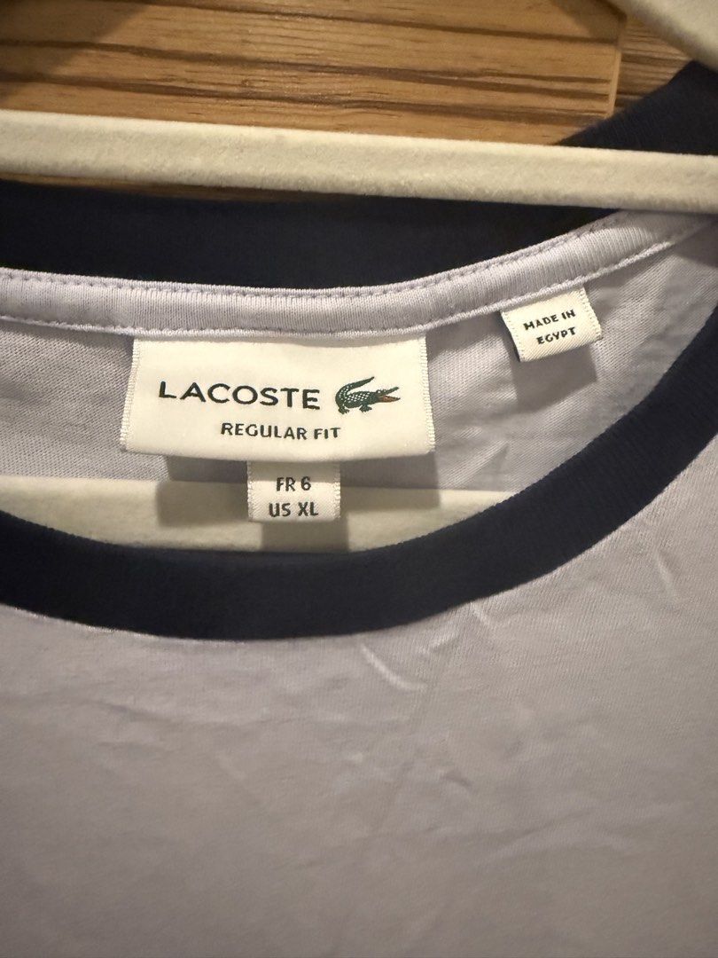 Lacoste Regular Fit T-shirt - White/Navy (Category: Tshirts & Polo Shirts ) located in Makati City. Submitted by stallionmegx (Listing ID 1463221975, Image 2). Description: - Classic Lacoste T-shirt - White body with navy blue sleeves and collar trim - Regular fit - Size XL - Made in Egypt - Ideal for casual wear.