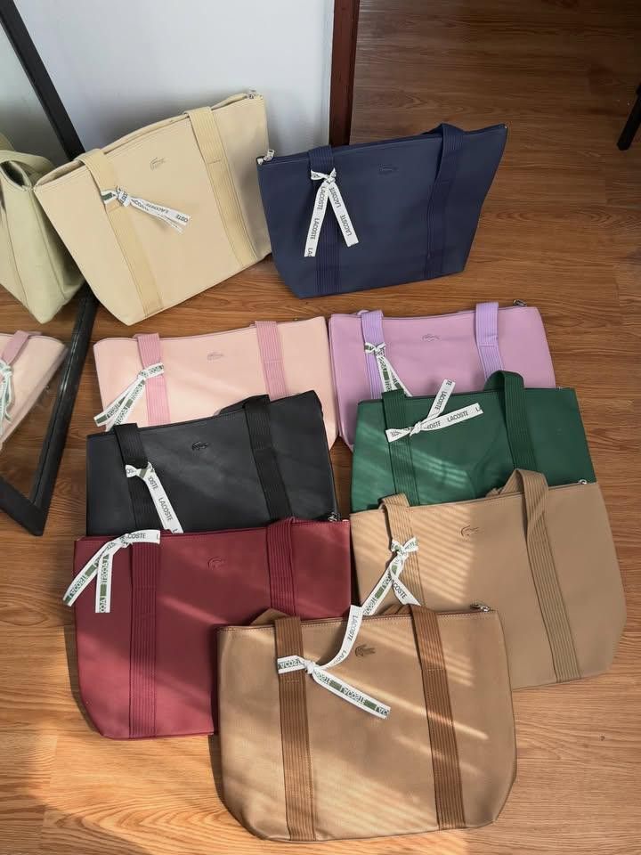 Lacoste Tote Bag - Multiple Colors Available (Category: Tote Bags) located in Floridablanca. Submitted by thrift_thrill (Listing ID 1463285615, Image 1). Description: - Cute Lacoste tote bags - Available in navy, pink, black, green, burgundy, beige, and tan - Ideal for everyday use - Features a small ribbon detail with the Lacoste logo - Spacious interior to carry all your essentials.