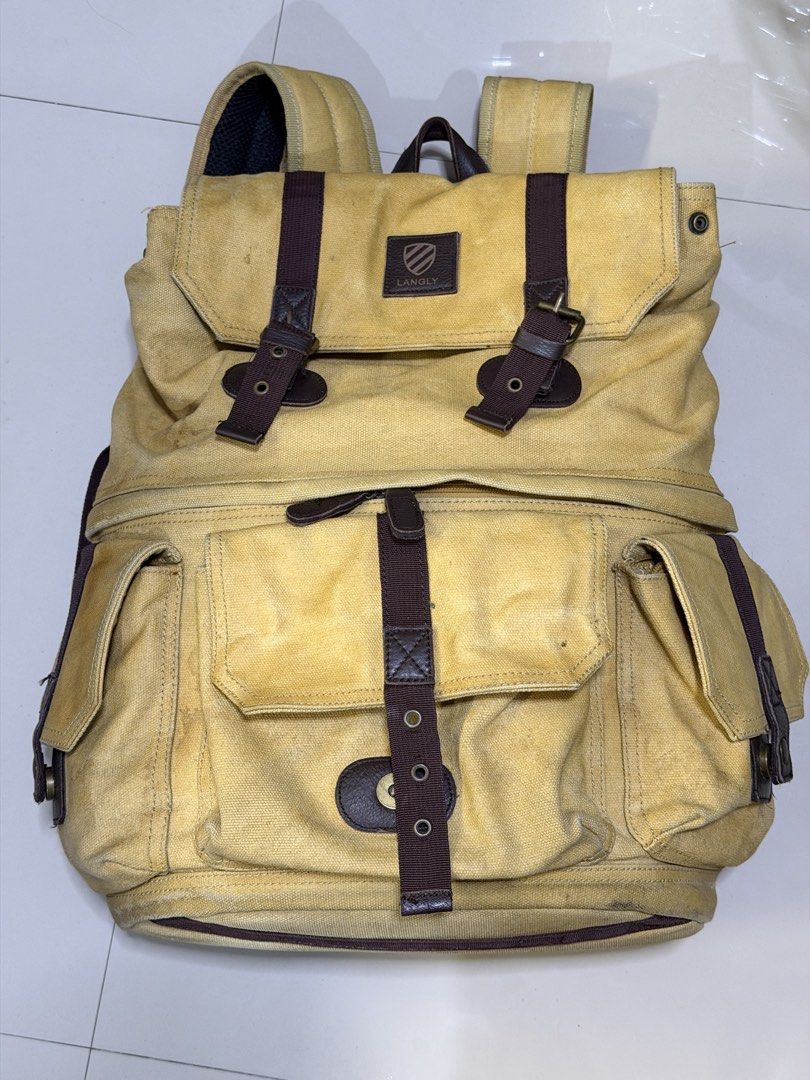 Langly Alpha Camera Bag (Category: Camera Bags & Carriers) located in Las Pinas. Submitted by fjoseiv (Listing ID 1463259462, Image 1). Description: - Khaki canvas backpack with stylish brown leather accents. - Multiple interior compartments, including padded sections for protection. - Two convenient front pockets with secure buckle closures. - Adjustable padded shoulder straps for comfortable carrying. - Versatile: perfect for everyday use or tr