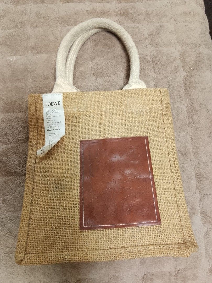 Loewe Jute Tote Bag (Category: Luxury Bags & Wallets) located in Talisay. Submitted by southernthrifts (Listing ID 1463136866, Image 1). Description: - Authentic Loewe Anagram tote bag - Material: Jute - Color: Natural beige - Features iconic Loewe anagram logo on leather patch - White handles - Ideal for everyday use or as a beach bag - Made in Spain.