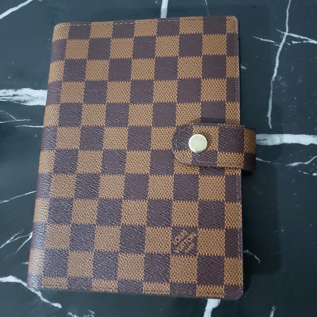 LV Damier Ebene Agenda size MM (Category: Luxury Bags & Wallets) located in Manila. Submitted by poshcara (Listing ID 1463227929, Image 1). Description: Louis Vuitton Agenda Cover - Classic Damier Ebene Canvas - Secure Snap Button Closure - Interior Card Slots - Convenient Pen Loop - Includes Address Book Insert - Ideal for Daily Scheduling & Contact Organization.