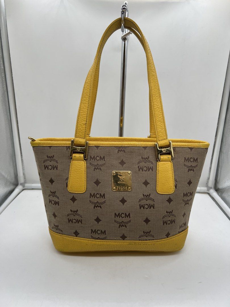 MCM monogram bright yellow leather trim tote bag (Category: Shoulder Bags) located in Cavite. Submitted by aellavier (Listing ID 1463146747, Image 1). Description: orig preloved auth. minimal signs of use/ needs cleaning sa yellow leather parts. needs canvas cleaning no major flaws .