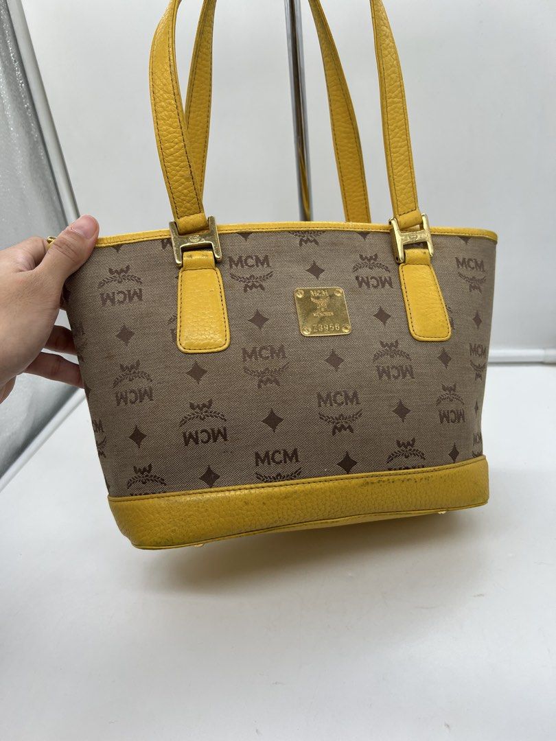 MCM monogram bright yellow leather trim tote bag (Category: Shoulder Bags) located in Cavite. Submitted by aellavier (Listing ID 1463146747, Image 2). Description: orig preloved auth. minimal signs of use/ needs cleaning sa yellow leather parts. needs canvas cleaning no major flaws .