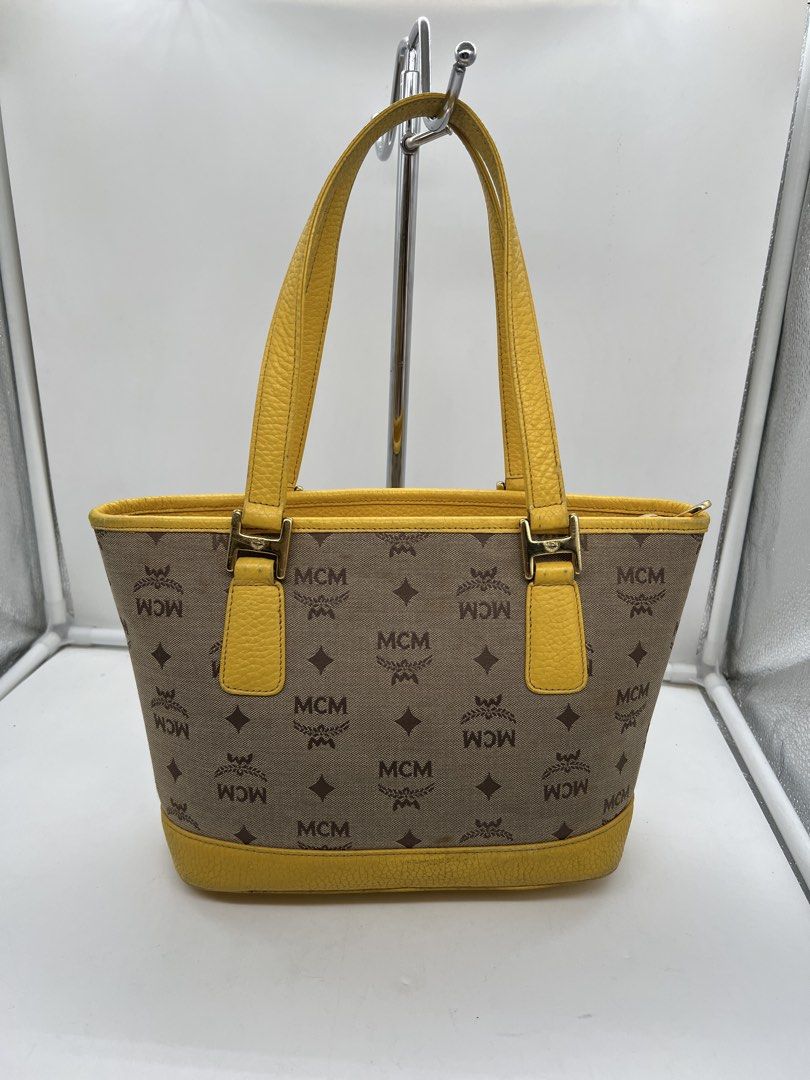 MCM monogram bright yellow leather trim tote bag (Category: Shoulder Bags) located in Cavite. Submitted by aellavier (Listing ID 1463146747, Image 3). Description: orig preloved auth. minimal signs of use/ needs cleaning sa yellow leather parts. needs canvas cleaning no major flaws .