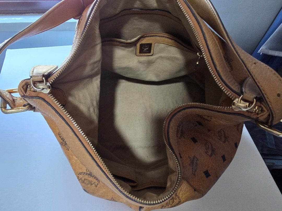 MCM Monogram Leather Hobo Shoulder Bag (Category: Luxury Bags & Wallets) located in Mandaluyong City. Submitted by artlin04 (Listing ID 1463180780, Image 2). Description: - Authentic MCM monogram hobo bag - Color: Brown leather - Hardware: Gold tone - Closure: Zipper - Interior: 1 zip pocket, slip pockets - Features: Leather trim and straps, studded base for protection - Style: Great everyday bag - large and spaceous - can fit a 13inch laptop - i