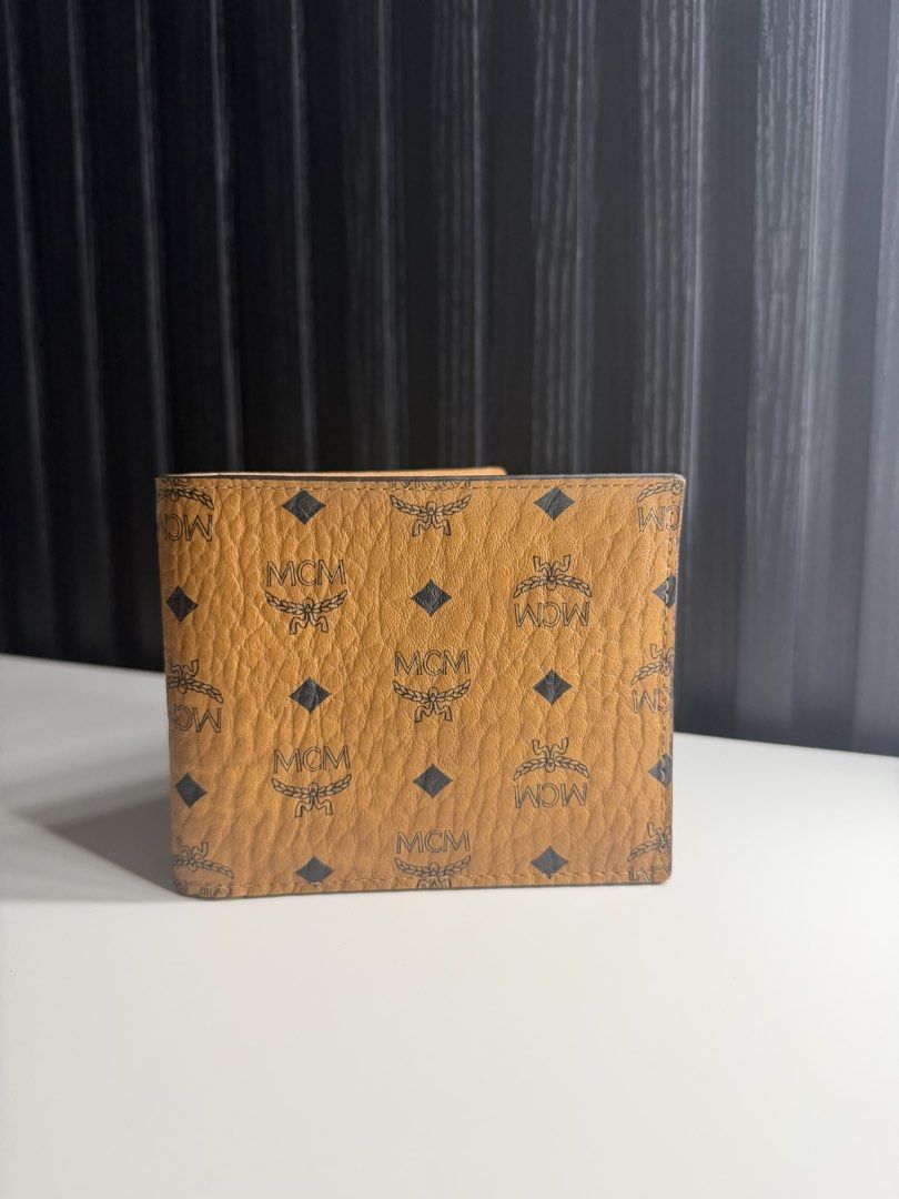 MCM Wallet (Category: Luxury Bags & Wallets) located in Paranaque City. Submitted by miggyfeliciano (Listing ID 1463195097, Image 1). Description: MCM Walllet PRICE: ₱6,000 CONDITION: Good as new. DETAILS: * Classic MCM Visetos monogram exterior * Cognac/tan color * Bi-fold design * Multiple card slots (8 card slots) * Large bill compartment INCLUSIONS: Wallet only MODE OF PAYMENT: Cash/BPI Online Transfer REASON FOR SELLING: Decluttering MEETUP 