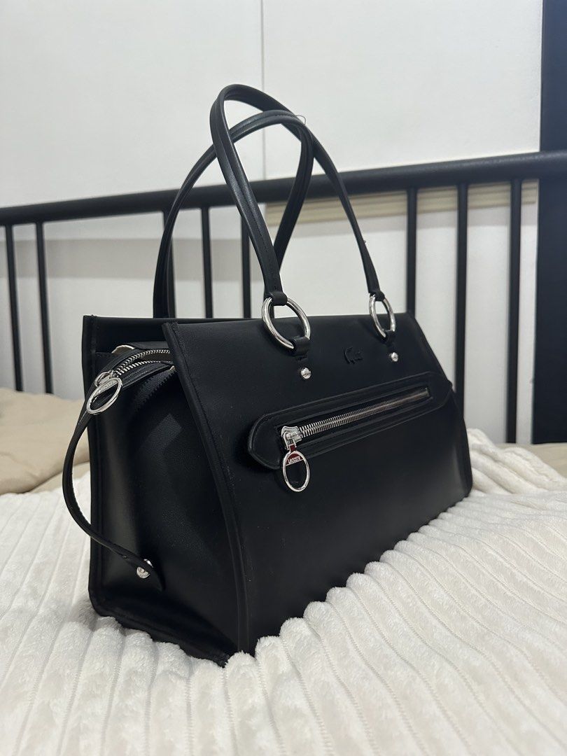 Medium Celys Top Handle Bag (Category: Tote Bags) located in Manila. Submitted by ana_south (Listing ID 1463162677, Image 3). Description: - Classic black Lacoste tote bag - Features silver hardware details (zippers, ring accents) - Main compartment with zip closure - Two top handles for carrying - Simple and chic design - Ideal for everyday use or work RFS: not my preference anymore.