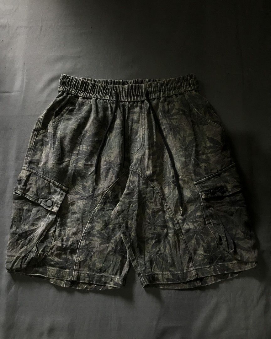 Men's Cargo Shorts with Leaf Pattern (Category: Shorts) located in Daraga. Submitted by jcaa2415 (Listing ID 1463125665, Image 2). Description: - Dark green cargo shorts - Subtle all-over leaf pattern - Elastic waistband with drawstring - Two side pockets - Two button-closure cargo pockets - Comfortable fit for casual, everyday wear.