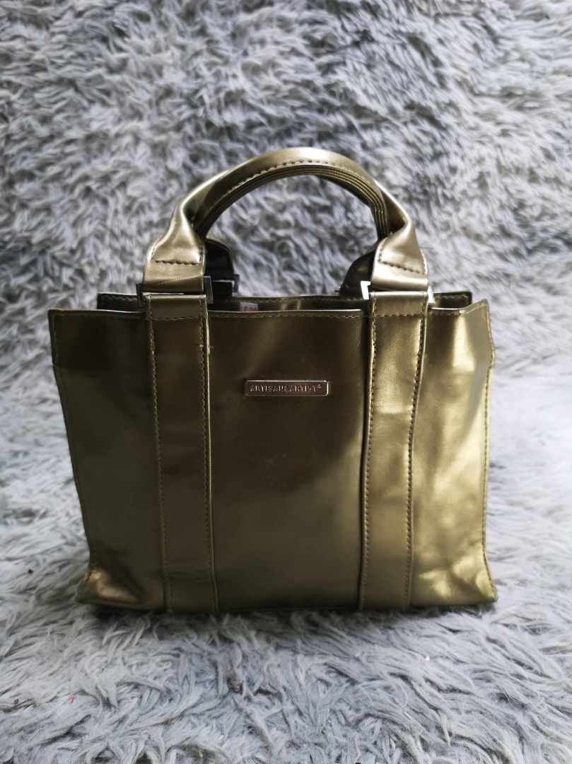 Metallic Gold Tone Structured Top Handle Tote Bag (Category: Tote Bags) located in Santa Cruz. Submitted by jmy_surplus.2 (Listing ID 1463124528, Image 1). Description: Size ; L - 7.6 W - 9.6 Color ; Gold Type ; Tote Bag Brand ; No brand Material ; Synthetic Style ; Metallic Gold Tote Bag LR 129 JMY 3 Batch #223.