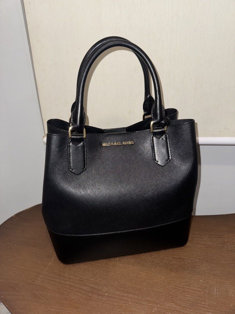 Michael Kors Black Leather Tote Bag (Category: Luxury Bags & Wallets) located in Taguig. Submitted by findfendifirst (Listing ID 1463240165, Image 1). Description: Guaranteed authentic. Very nice and spacious. Comes with shoulder strap RFS decluttering - Classic black Michael Kors tote bag - Genuine saffiano leather exterior with smooth leather trim - Elegant gold hardware details - Interior zip pocket for secure storage - Includes a convenient c