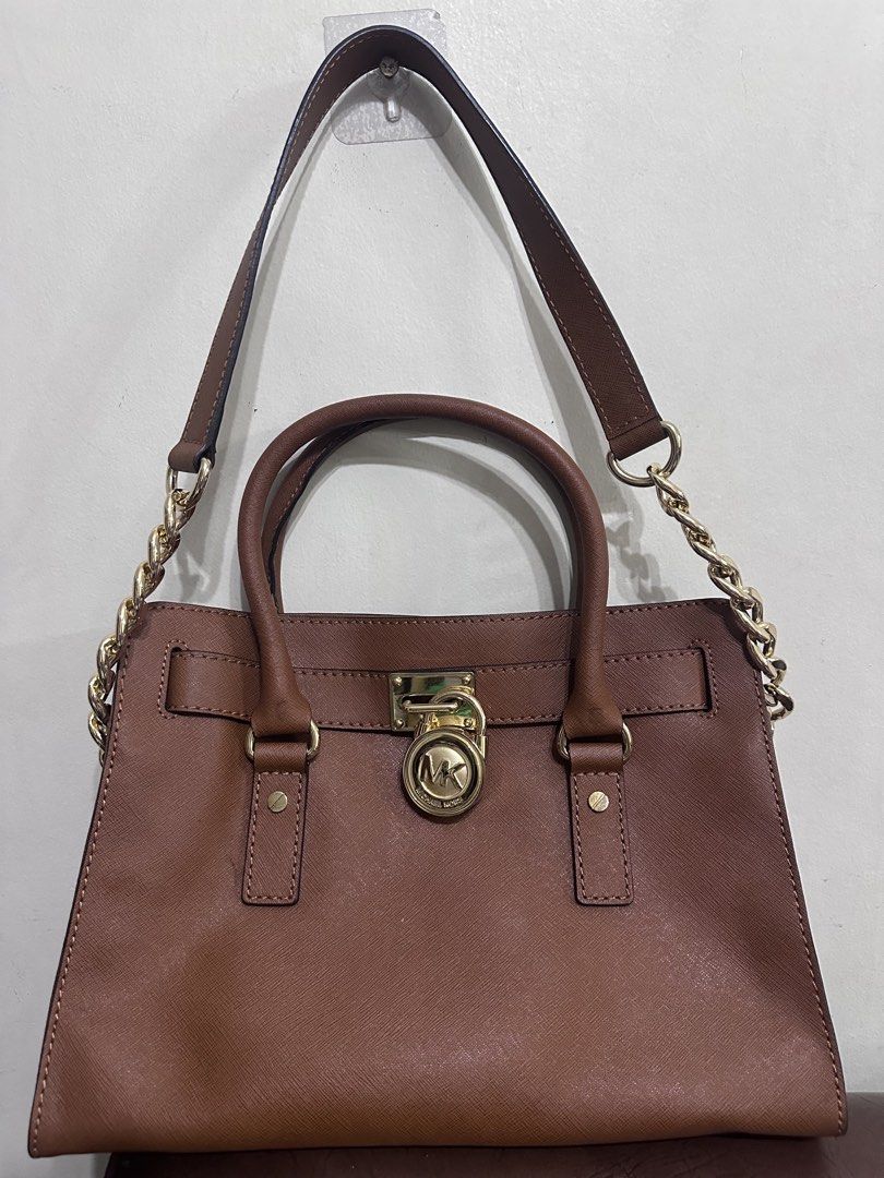Michael Kors Brown Hamilton Satchel (Category: Luxury Bags & Wallets) located in Manila. Submitted by shopaholic_gurl (Listing ID 1463219917, Image 3). Description: - Genuine brown saffiano leather Michael Kors satchel - Elegant gold hardware details - Versatile with top handle and detachable crossbody strap -mid sized hamilton fits ipad - Interior includes a zip pocket and slip pockets for organization - Spotless interior, ready for immediate us