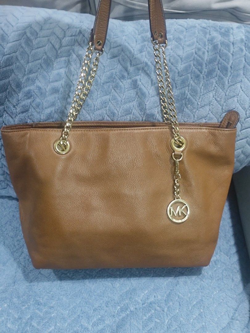 Michael Kors Brown Leather Chain Tote Bag (Category: Luxury Bags & Wallets) located in Cainta. Submitted by luxesparkle (Listing ID 1463265541, Image 1). Description: - Authentic Michael Kors brown leather tote bag - Elegant gold chain detailing on straps - Spacious interior with multiple compartments - Includes a secure zip pocket - Versatile for everyday use or evening events.