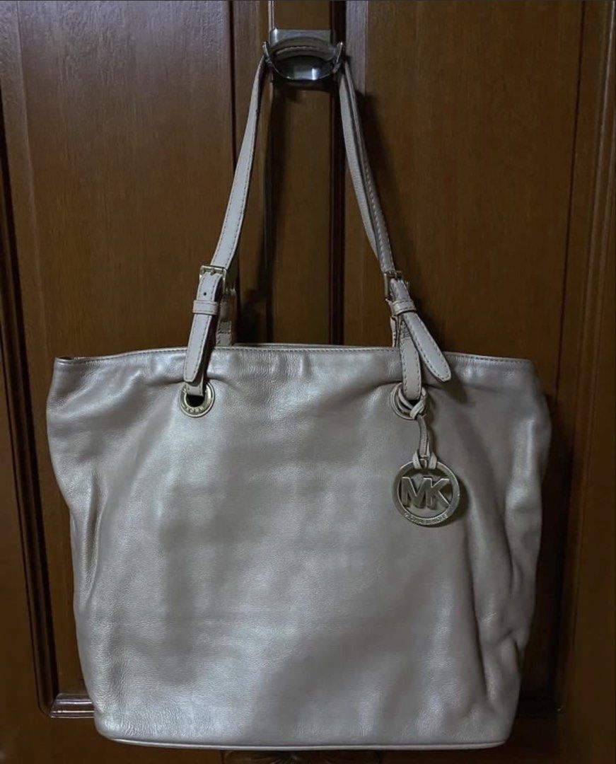 Michael Kors Gold Leather Tote Bag (Category: Luxury Bags & Wallets) located in Pasig City. Submitted by aprilluxcloset0812 (Listing ID 1463127086, Image 3). Description: - Genuine Michael Kors Gold Leather Tote Bag - with minor rubs in the leather handle (price negotiable) - Secure zip closure - Spacious interior with multiple pockets - Protective metal feet on the bottom - Includes signature MK charm - Ideal for everyday use or travel PAKIBASA 
