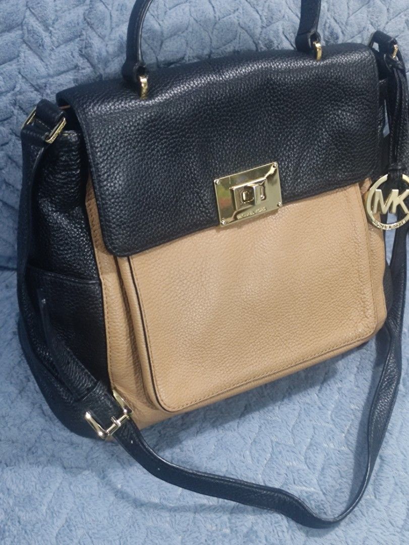 Michael Kors Leather Two-Tone Handbag (Category: Luxury Bags & Wallets) located in Cainta. Submitted by luxesparkle (Listing ID 1463265794, Image 2). Description: - Authentic Michael Kors handbag - Chic black and tan leather combination - Secure gold clasp closure - Lined interior with convenient pockets - Detachable long shoulder strap included - Versatile for everyday wear or dressing up.