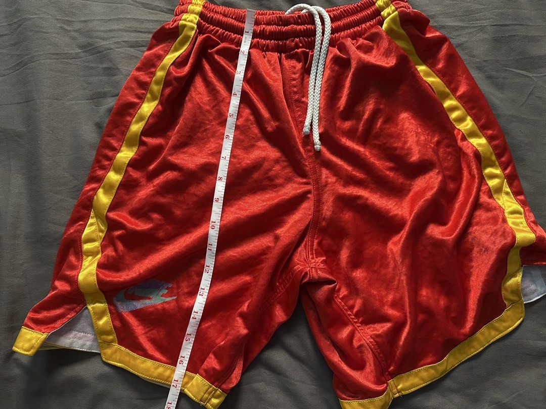 Microshiny Red & Yellow Basketball Shorts (Category: Shorts) located in Manila. Submitted by shoriljane (Listing ID 1463237356, Image 2). Description: - Red Nike basketball shorts - Yellow trim detail - Elastic waistband with drawstring - Visible Nike logo on left leg - Light pink interior lining - Ideal for sports and casual wear - Approximate measurements: 15" length, 22-30" waist.