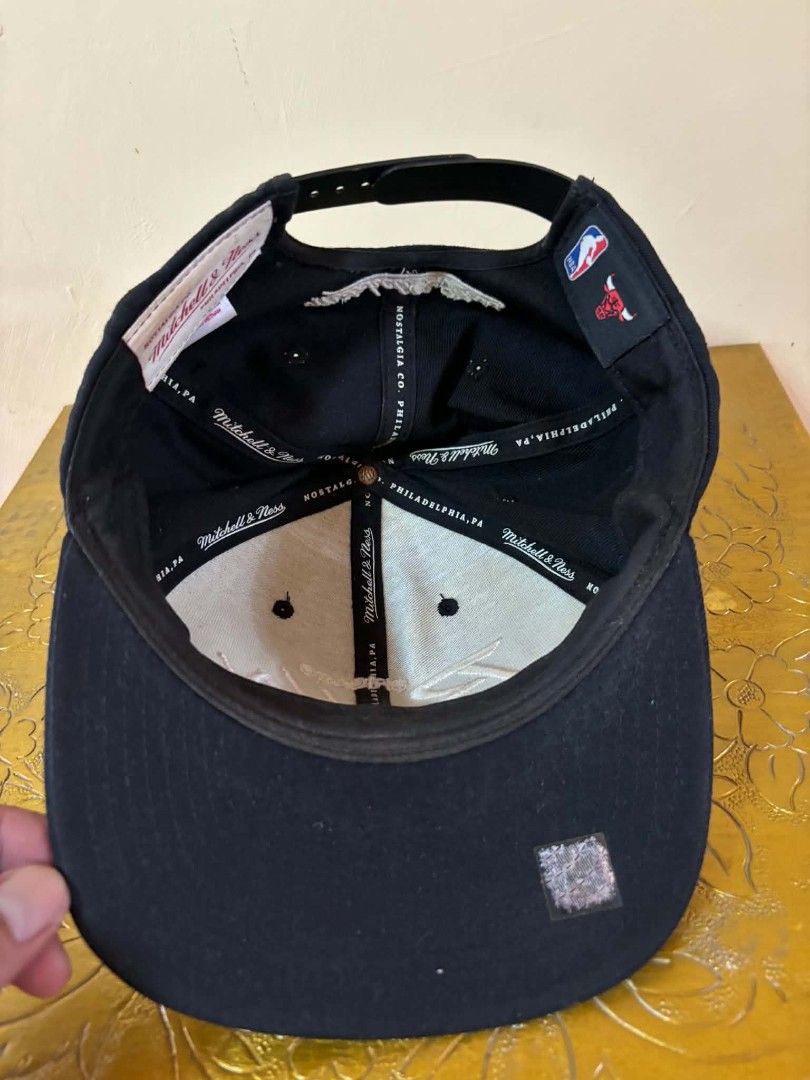 Mitchell & Ness Chicago Bulls Snapback Cap (Category: Caps & Hats) located in Daet. Submitted by jemotovlog28 (Listing ID 1463285422, Image 2). Description: - Brand: Mitchell & Ness - Team: Chicago Bulls - Color: Black - Features: Embroidered 'Chicago Bulls' logo on front - Closure: Adjustable snapback - Origin: Made in Vietnam - Condition: Shows some signs of wear on the brim and inside.