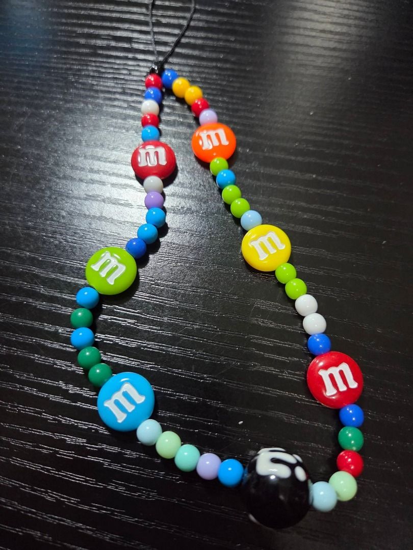 "M&M" iPhone 12 Pro phone case (Category: Cases & Sleeves) located in Quezon City. Submitted by ianelles.closet (Listing ID 1463148326, Image 2). Description: Phone case Stand holder Lanyard 3D Stickers for phone case. rfs: wrong model ang nabili.