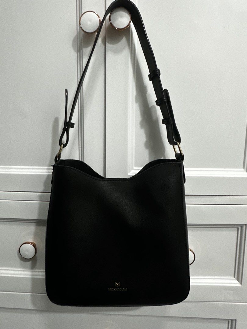 Mossdom Black Leather Bucket Bag (Category: Shoulder Bags) located in Guagua. Submitted by adventurousa (Listing ID 1463126259, Image 1). Description: - Classic black bucket bag from Mossdom - Made of textured leather - Magnetic snap closure - Interior pockets for organization - Adjustable strap - Great everyday bag - Clean inside and out.