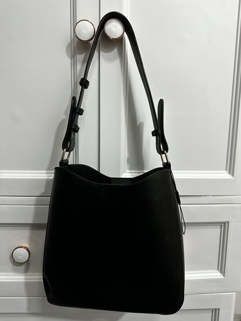 Mossdom Black Leather Bucket Bag (Category: Shoulder Bags) located in Guagua. Submitted by adventurousa (Listing ID 1463126259, Image 3). Description: - Classic black bucket bag from Mossdom - Made of textured leather - Magnetic snap closure - Interior pockets for organization - Adjustable strap - Great everyday bag - Clean inside and out.