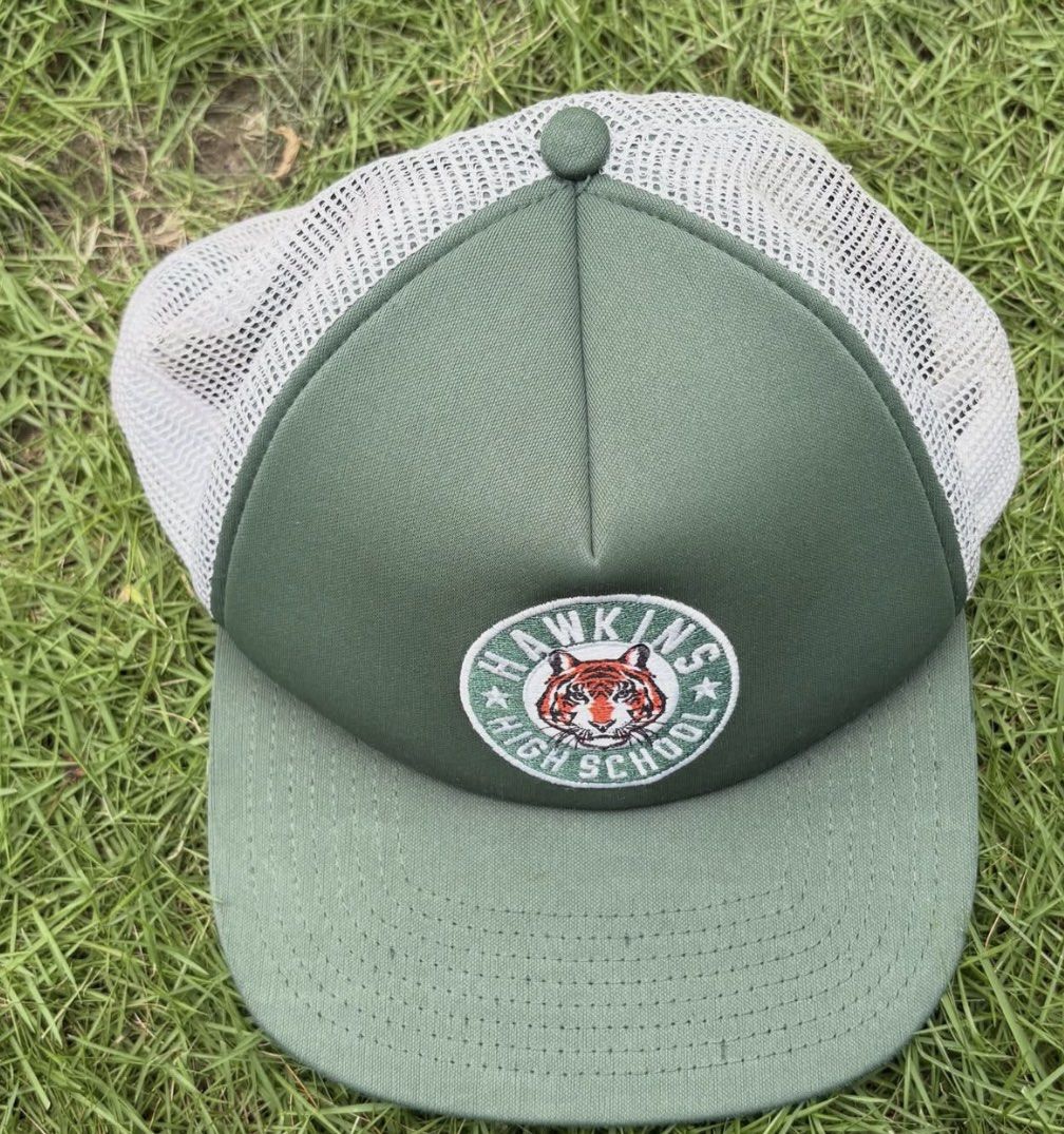 Nike Stranger Things Hawkins High School Trucker Hat (Category: Caps & Hats) located in Tuguegarao City. Submitted by verfjmin (Listing ID 1463301065, Image 1). Description: - Green trucker hat with Hawkins High School logo - Features a tiger graphic on the patch - White mesh back for breathability - Adjustable size for a comfortable fit - Nike tag inside.
