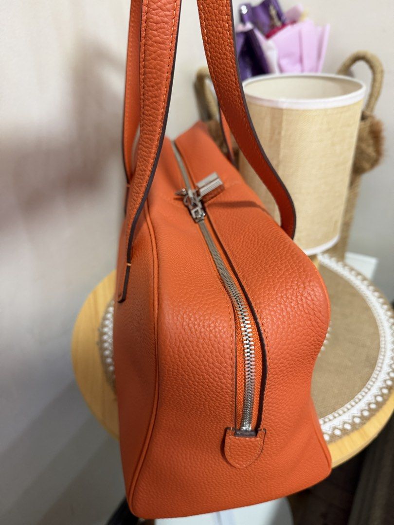Orange Leather Handbag with Lock and Key (Category: Luxury Bags & Wallets) located in Manila. Submitted by madsdedios05212 (Listing ID 1463231915, Image 2). Description: - Vibrant orange textured leather handbag - Secure zipper closure with included lock and key - Comfortable top handles for easy carrying - Detachable strap for versatile wear - Spacious interior to hold all your essentials - Ideal for everyday use.