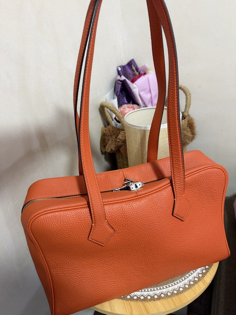 Orange Leather Handbag with Lock and Key (Category: Luxury Bags & Wallets) located in Manila. Submitted by madsdedios05212 (Listing ID 1463231915, Image 1). Description: - Vibrant orange textured leather handbag - Secure zipper closure with included lock and key - Comfortable top handles for easy carrying - Detachable strap for versatile wear - Spacious interior to hold all your essentials - Ideal for everyday use.