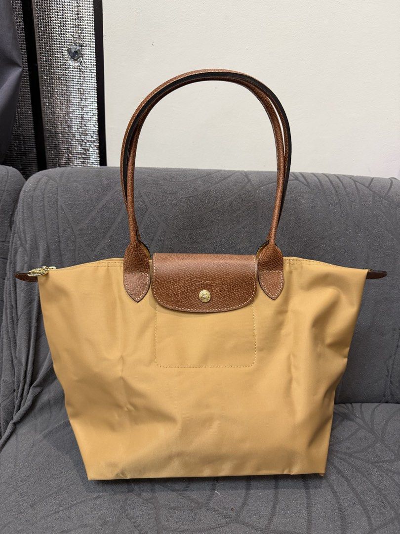 Original Longchamp Le Pliage medium (Category: Luxury Bags & Wallets) located in Manila. Submitted by sberja07 (Listing ID 1463226508, Image 1). Description: Preloved but quality is 9/10 Color: caramel Size: medium Slightly negotiable Pick up loc: bacoor cavite - Classic Longchamp tote bag - Light brown color - Durable nylon body with leather handles and trim - Secure zipper closure with snap tab - Spacious interior for daily essentials - Folds f