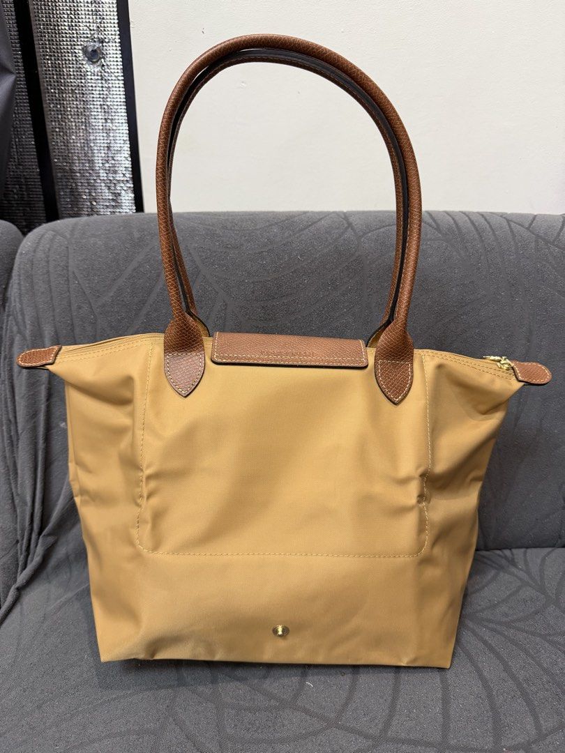 Original Longchamp Le Pliage medium (Category: Luxury Bags & Wallets) located in Manila. Submitted by sberja07 (Listing ID 1463226508, Image 2). Description: Preloved but quality is 9/10 Color: caramel Size: medium Slightly negotiable Pick up loc: bacoor cavite - Classic Longchamp tote bag - Light brown color - Durable nylon body with leather handles and trim - Secure zipper closure with snap tab - Spacious interior for daily essentials - Folds f