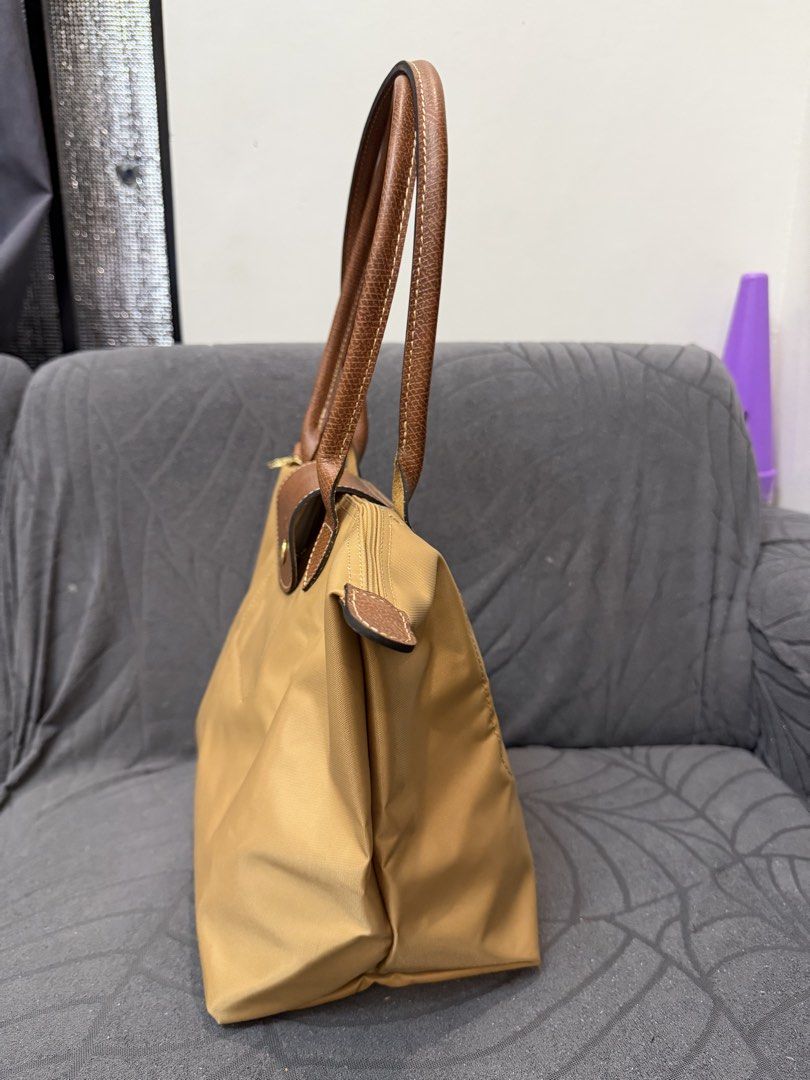 Original Longchamp Le Pliage medium (Category: Luxury Bags & Wallets) located in Manila. Submitted by sberja07 (Listing ID 1463226508, Image 3). Description: Preloved but quality is 9/10 Color: caramel Size: medium Slightly negotiable Pick up loc: bacoor cavite - Classic Longchamp tote bag - Light brown color - Durable nylon body with leather handles and trim - Secure zipper closure with snap tab - Spacious interior for daily essentials - Folds f