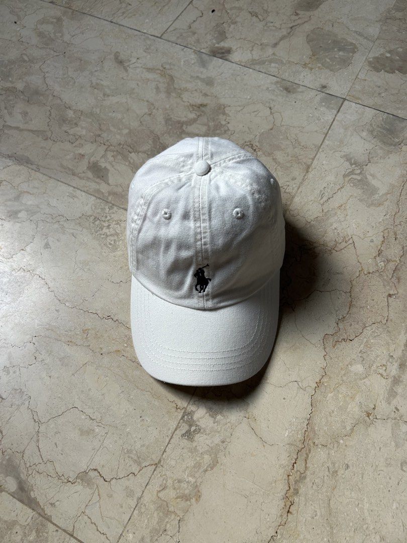 Polo Ralph Lauren White Baseball Cap (Category: Caps & Hats) located in Muntinlupa City. Submitted by wavesofara (Listing ID 1463126063, Image 1). Description: - Classic white Polo Ralph Lauren cap - Iconic polo player logo embroidered on the front - Adjustable strap at the back for a comfortable fit - Simple and versatile design - Ideal for everyday wear.