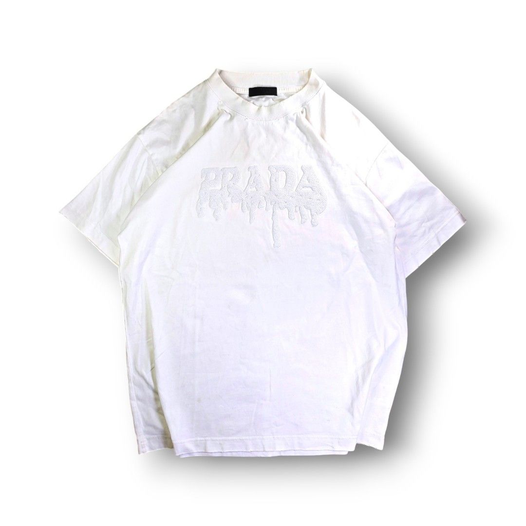 Prada Milano Dripping Carpetized Logo Distressed White Crew Neck Tee (Category: Tshirts & Polo Shirts ) located in San Pedro. Submitted by chronothrift2ndacc (Listing ID 1463183947, Image 1). Description: - Size: XL (W23 x 30L) - Condition: 9.2/10 - Color Rate: 9/10 - Flaws: ❌❌❌ MOD: J&T Express / Lalamove / Meet MOP: Gcash / Bank Transfer.