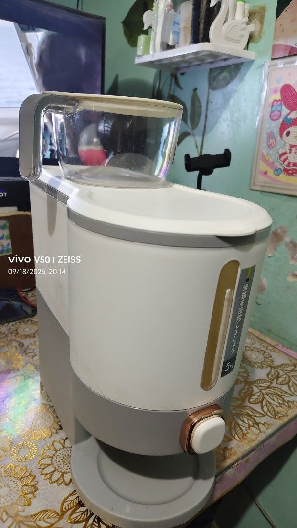 Preloved Rice dispenser (Category: Other Kitchenware & Tableware) located in Manila. Submitted by chaychayprelovedshop (Listing ID 1463323807, Image 1). Description: - White and grey rice dispenser - Includes glass carafe and lid - rice level indicator on the side - Stylish rose gold accent knob - Tested and confirmed working.