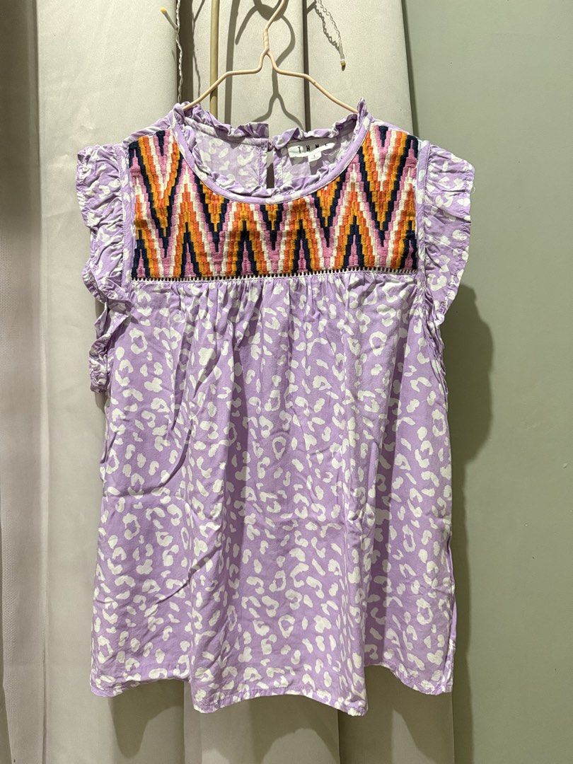 Purple Leopard Print Top with Aztec Neckline (Category: Sleeveless) located in Cagayan de Oro. Submitted by ninaaam (Listing ID 1463271460, Image 1). Description: - Adorable purple top with a chic white leopard print. - Features a vibrant, Aztec-inspired embroidered neckline. - Charming ruffled cap sleeves for a feminine touch. - Convenient button closure at the back. - Ideal for a stylish and comfortable casual outfit..
