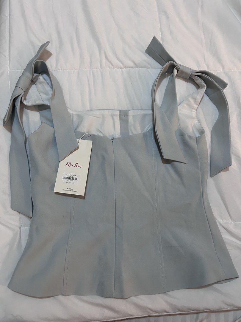 Rechic Square Neck Top Bow Light Blue (Category: Blouses) located in Paranaque City. Submitted by bahotaho (Listing ID 1463280797, Image 2). Description: - Bought in Hanoi Vietnam last Dec 2025 for 545k VND (~₱1300) - Tried on once, had it altered to fit my frame (Small to Medium) - Still has tag attached - This best fits a medium now despite being XL on tag - Such a pretty color and so flattering! - Very structured (material feels like those use