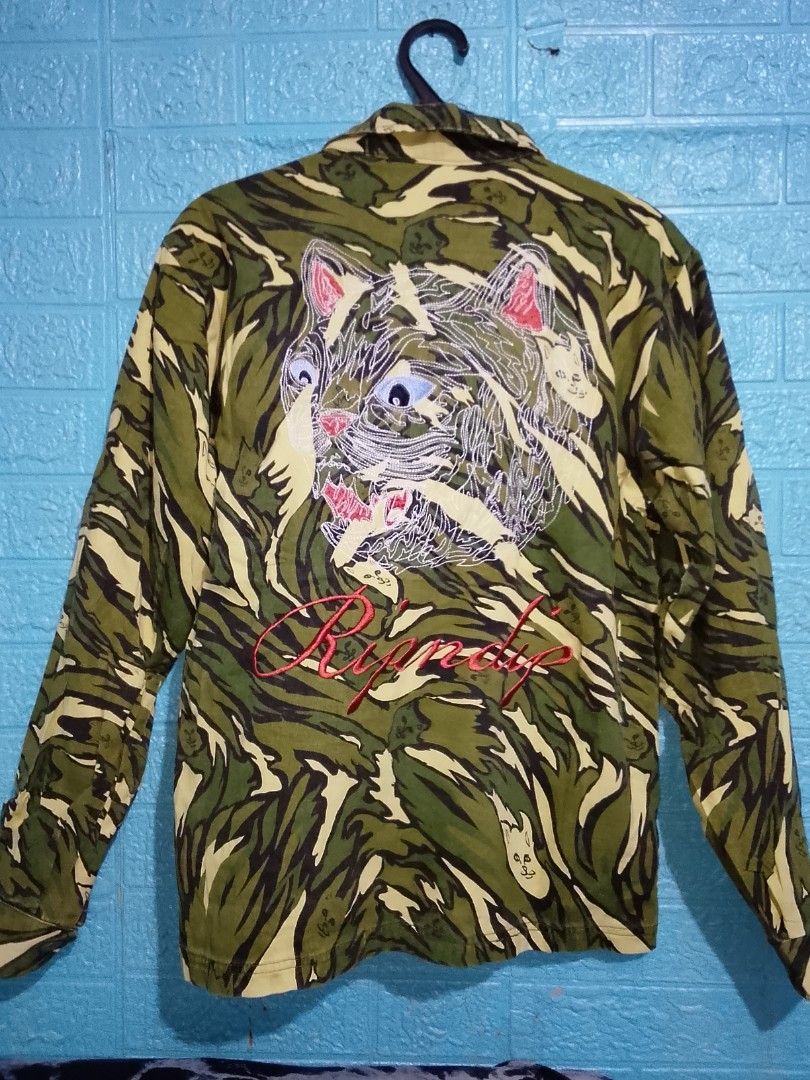 RIPNDIP Tiger Camo Jacket with Embroidered Cat (Category: Coats, Jackets and Outerwear) located in Las Pinas. Submitted by solisjethr46316 (Listing ID 1463241017, Image 2). Description: - RIPNDIP jacket in tiger camo pattern - All-over embroidered cats on the front - Large embroidered cat face and RIPNDIP logo on the back - Size S - Ideal for casual wear.
