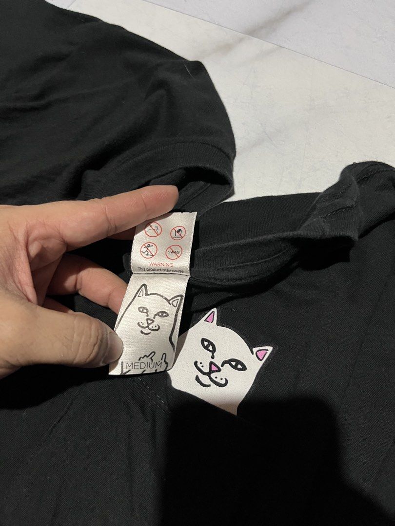 RIPNDIP T-Shirt Black Pocket Tee (Category: Tshirts & Polo Shirts ) located in Cavite. Submitted by christianzuuu (Listing ID 1463133697, Image 2). Description: - Brand: RIPNDIP - Color: Black - Size: Medium - Design: Iconic RIPNDIP middle finger cat logo on chest pocket - Material: Comfortable fabric - Occasion: Perfect for casual wear.