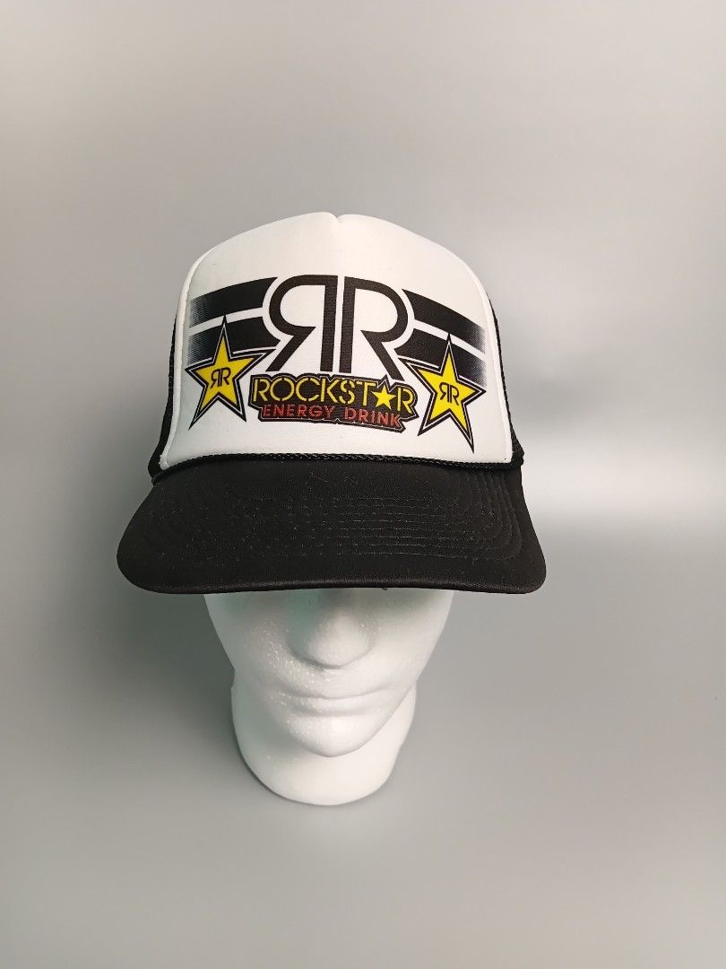 Rockstar Energy Drink trucker hat (Category: Caps & Hats) located in Manila. Submitted by hustler_777 (Listing ID 1463247175, Image 1). Description: designed with a distinctive black-and-white color block scheme. It has a white foam front panel, a black brim, and a breathable black mesh back. The front showcases a prominent "RR" logo framed by stylized black wing graphics and flanked by two yellow star emblems containing a red "SR" monogram. Unde