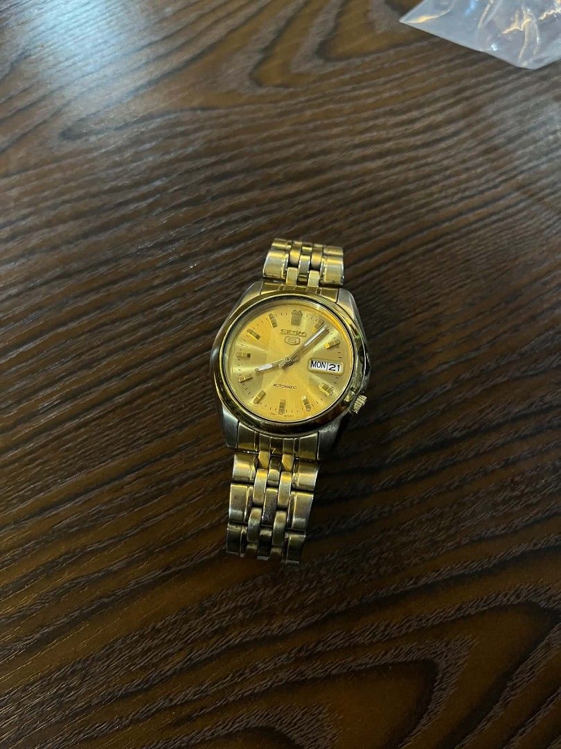 Seiko 5 Automatic Gold Tone Men's Watch (Category: Men's Watches) located in Cebu City. Submitted by jbok_watches. (Listing ID 1463260671, Image 1). Description: - Gold tone Seiko 5 automatic watch - Features day and date display - Stainless steel band - Shows some signs of wear on bracelet and case - Watch is currently running - Selling as is.