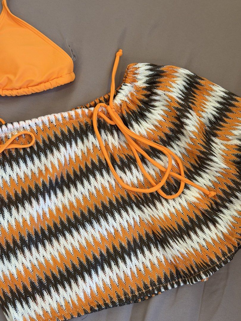 SHEIN Swim Orange Bikini Set with Patterned Shorts (Category: Bikinis & Swimsuits) located in Bulacan. Submitted by preloved_bygrace (Listing ID 1463125442, Image 3). Description: - Vibrant orange bikini top and bottoms. - Includes matching shorts with a stylish zigzag pattern in orange, white, and brown. - Shorts feature a convenient drawstring waist for adjustable fit. - Material: 80% Nylon, 20% Spandex Note: Color may vary due to lighting. RFS