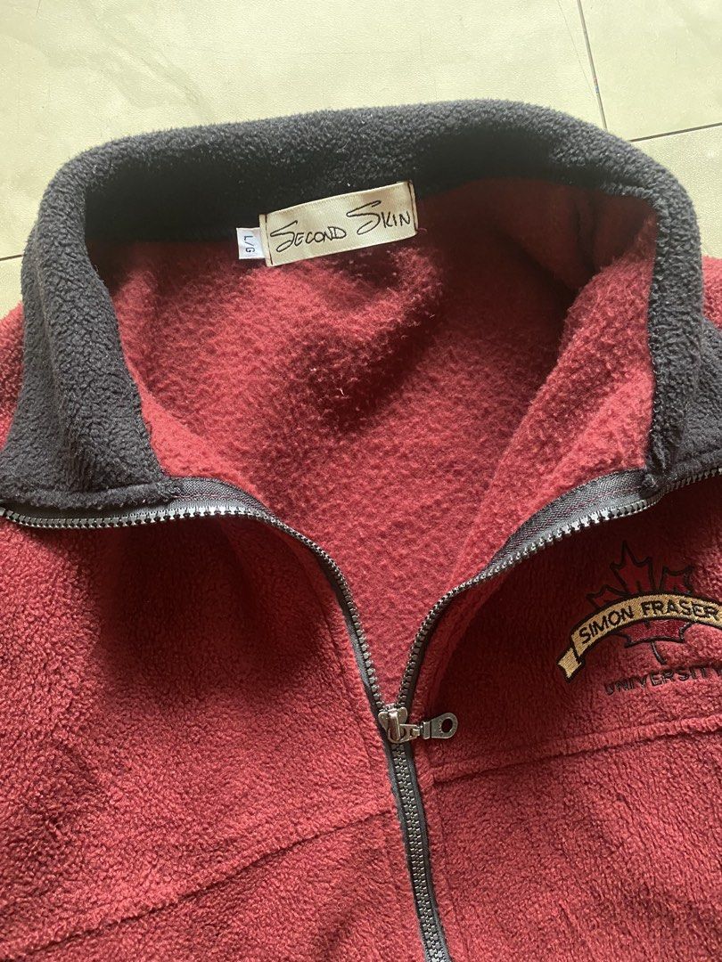 Simon Fraser Fleece Jacket (Category: Coats, Jackets and Outerwear) located in Cabuyao City. Submitted by kekjct (Listing ID 1463241027, Image 3). Description: Condition: 10/10 Size: Boxy Fit — 23” Pit-to-Pit × 27” Length (Tag L) Color: Maroon / Burgundy / Wine Red Details: • Embroidered “Simon Fraser University” maple leaf logo on chest • High-collar full-zip polar fleece construction • Elastic binding on collar, cuffs, and hem • Dual front hand