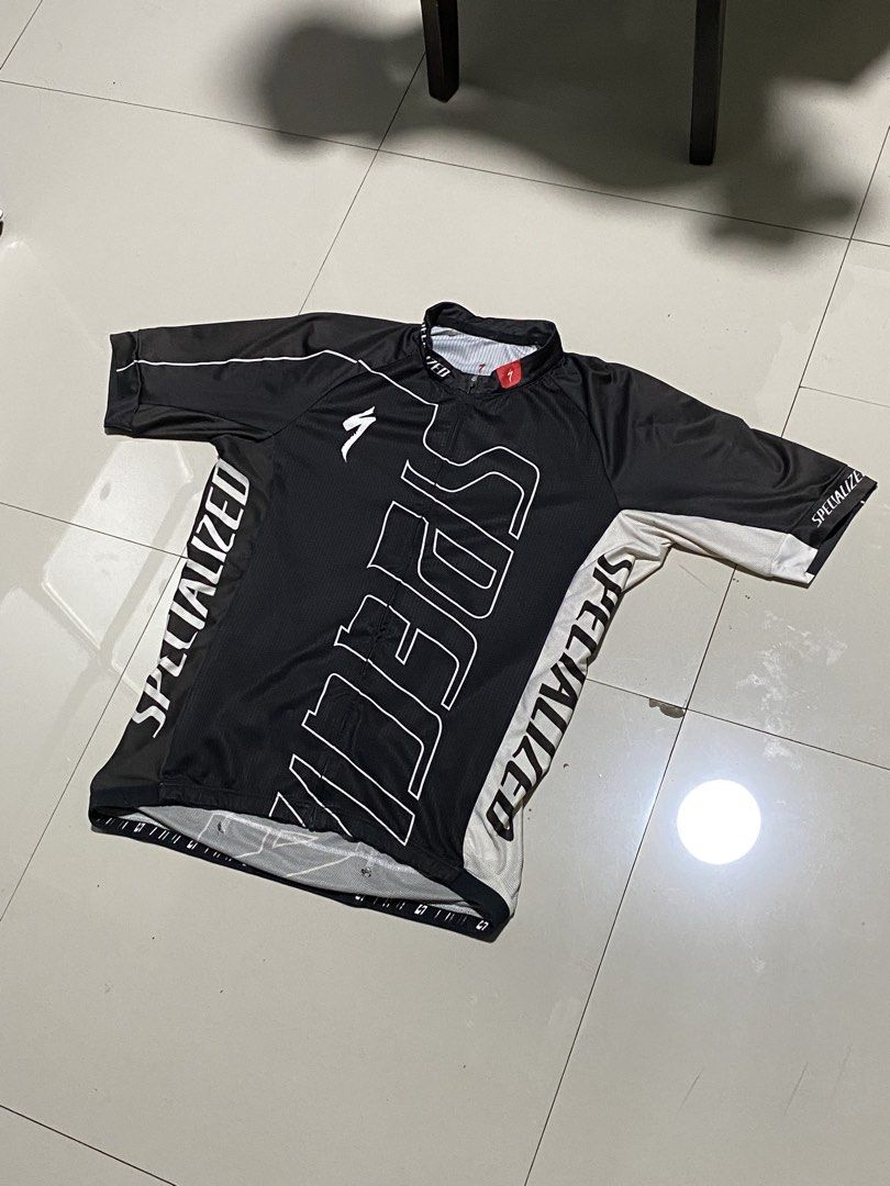 Specialized Short Sleeve Cycling Jersey XL (Category: Activewear) located in Baguio. Submitted by yunothewizardking (Listing ID 1463230571, Image 1). Description: - Specialized cycling jersey - Color: Black with white and grey accents - Features large Specialized branding on front and sleeves - Zippered collar for adjustable ventilation - Size: XL - Made in China - Ideal for your next cycling adventure.