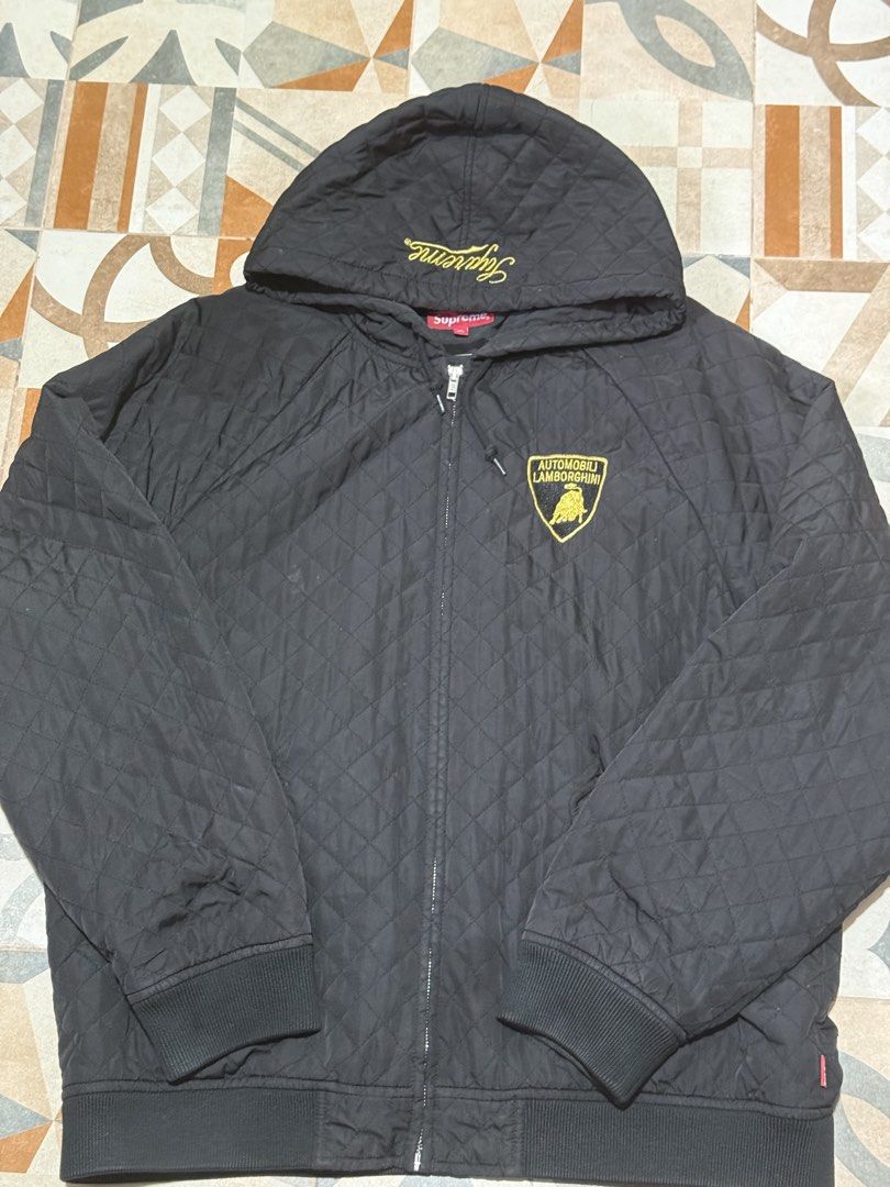 Supreme Lamborghini Quilted Jacket Black (Category: Coats, Jackets and Outerwear) located in Baguio. Submitted by shadaxcel (Listing ID 1463321781, Image 2). Description: - Supreme x Lamborghini collaboration bomber jacket - Color: Black - Quilted design - Full zip closure with hood - Iconic Lamborghini shield logo on back - Smaller Lamborghini logo on chest - Ribbed cuffs and hem - Material: 100% Polyester - Perfect for fans of Supreme and Lambo
