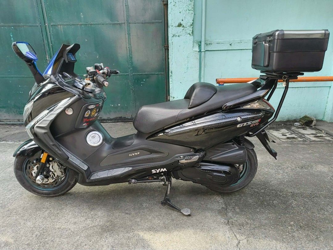 SYM GTS 300i EVO Scooter with Top Box (Category: Motorbikes for Sale) located in Caloocan City. Submitted by sab418 (Listing ID 1463155126, Image 1). Description: SYM GTS 300i EVO COMPLETE ORIGINAL OR CR with PLATE ✅Washable Air filter ✅Windshield DCR Style ✅LED Headlight with High & Low ✅DCR Drag Bar ✅DCR Break Lever ✅Carbon Fiber(some parts) ✅CP Holder Installed ✅Rear Double Contact Signal Light ✅Front and Rear Dash Cam w/ TPMS ✅Pirelli Diablo 