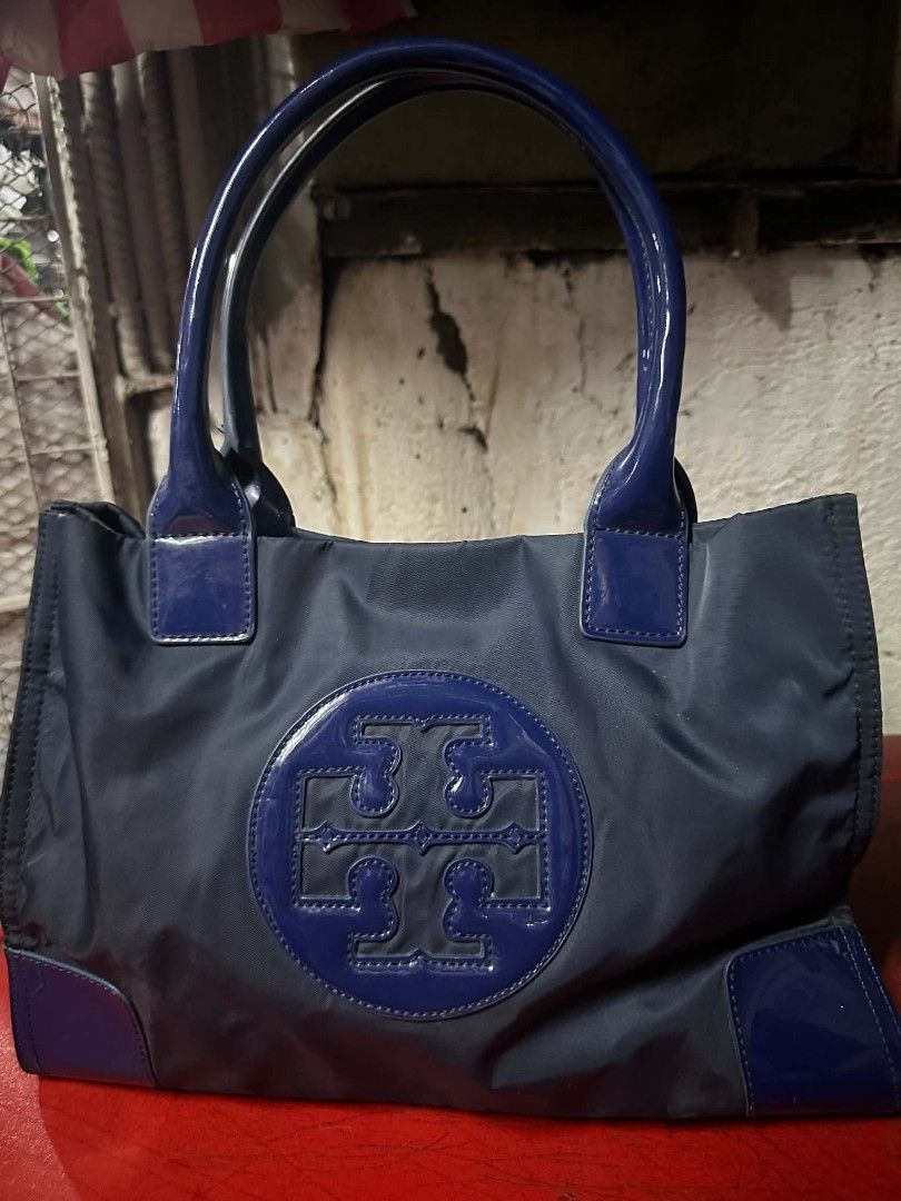 Tory Burch Nylon Tote Bag Navy Blue (Category: Luxury Bags & Wallets) located in Caloocan City. Submitted by rame_finds (Listing ID 1463295335, Image 1). Description: - Navy blue Tory Burch tote bag - Durable nylon material with patent leather accents - Iconic Tory Burch logo on the front - Spacious interior for all your essentials - Ideal for everyday use or travel.