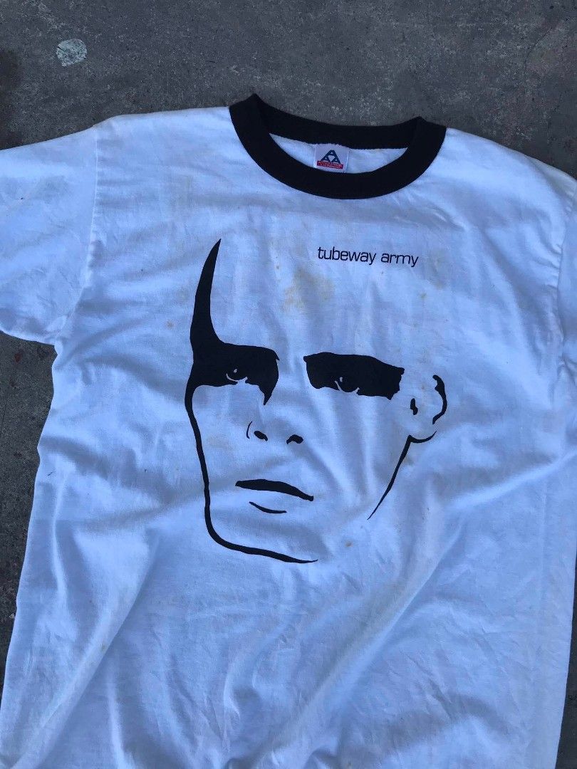 Tubeway Army Ringer T-Shirt (Category: Tshirts & Polo Shirts ) located in Manila. Submitted by youngstorm-c604 (Listing ID 1463168057, Image 3). Description: - White ringer t-shirt with black trim - Features Tubeway Army logo and face graphic on front - Made in Mexico - Size: Medium - Condition: Some faint yellowing/stains visible on fabric.