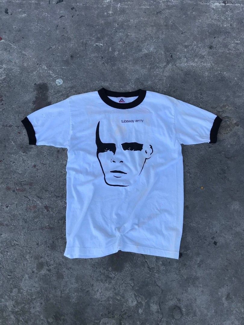 Tubeway Army Ringer T-Shirt (Category: Tshirts & Polo Shirts ) located in Manila. Submitted by youngstorm-c604 (Listing ID 1463168057, Image 1). Description: - White ringer t-shirt with black trim - Features Tubeway Army logo and face graphic on front - Made in Mexico - Size: Medium - Condition: Some faint yellowing/stains visible on fabric.