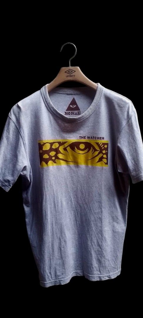 Vintage Custom-Printed ■ The Watcher #0003 (Category: Tshirts & Polo Shirts ) located in Cagayan de Oro. Submitted by jublamerba95478 (Listing ID 1463236855, Image 1). Description: - Grey t-shirt from the brand Nomad - Features a unique 'The Watcher' graphic print with an eye design - Classic short sleeves and crew neck style - Ideal for everyday casual outfits.