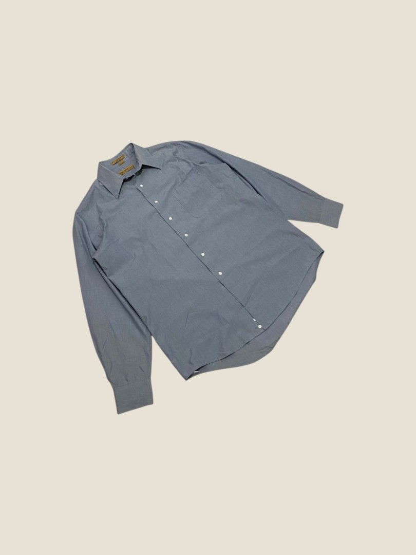 Vintage Milano Uomo Slate Blue Button-Down Shirt (Category: Formal Shirts) located in Santa Rosa. Submitted by revive.n.thrive (Listing ID 1463304901, Image 2). Description: A minimal essential tailored for an effortless preppy look and quiet luxury aesthetic. Rendered in a muted slate blue / chambray-style tone, this piece features a sharp pointed spread collar, clean front placket with pearl white buttons, and a single left chest pocket. Cut fr